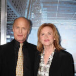 Two individuals posing together at a film premiere on the red carpet