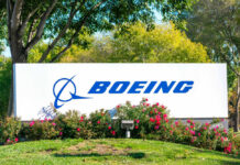 Boeing logo on sign with flowers and trees