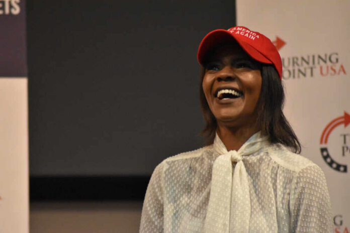 A woman wearing a red cap smiling and speaking at an event