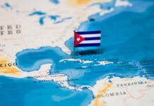 A small Cuban flag placed on a map highlighting Cuba in the Caribbean