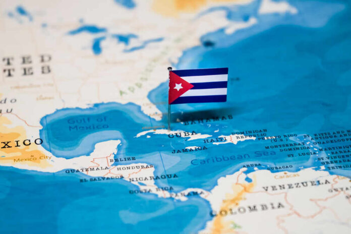 A small Cuban flag placed on a map highlighting Cuba in the Caribbean