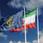Two flags waving against a blue sky