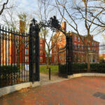 Fraud-Busting Startup Challenges Federal Giants Iron gate opening to a historic university campus with red brick buildings