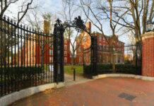 Fraud-Busting Startup Challenges Federal Giants Iron gate opening to a historic university campus with red brick buildings