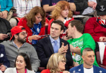 A diverse group of people at a political rally, some engaged in conversation
