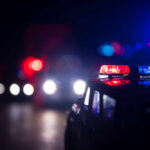 Close-up of a police car model with flashing lights in a dark setting