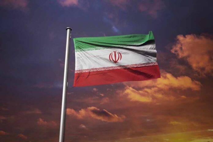 Iranian flag waving against a sunset sky