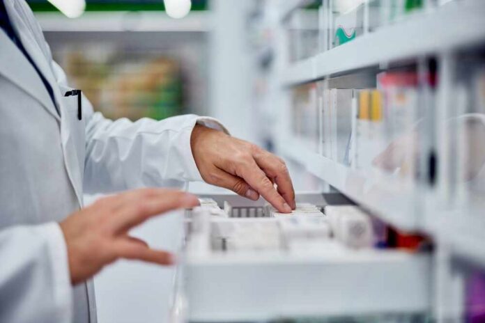 Pharmacist organizing medication on a shelf