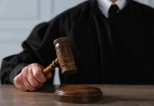 A judge holding a gavel above a wooden block