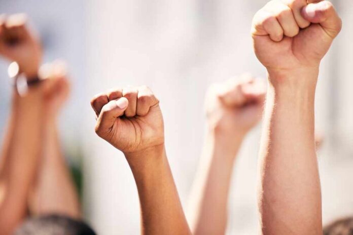 Multiple raised fists in a show of solidarity during a protest