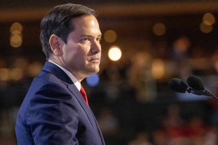 A man in a suit speaking at a podium with microphones