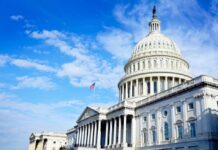 The U.S. Capitol building with an American flag flying under a blue sky