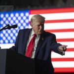 Trump’s Alleged Dementia: Media Bias or Truth? A man in a suit gestures while speaking at a podium with an American flag in the background