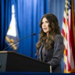 A woman speaking at a podium during a press conference