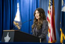 A woman speaking at a podium during a press conference