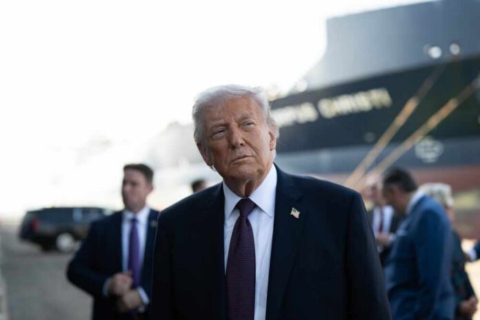 A political figure standing outdoors with a serious expression