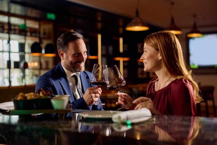 A couple toasting with wine glasses at a restaurant