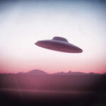 UFO flying over mountains during sunset or sunrise