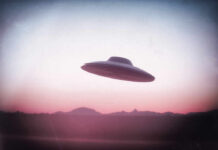 UFO flying over mountains during sunset or sunrise