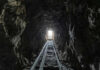 Dark tunnel leading to bright exit with tracks