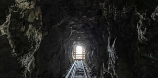 Dark tunnel leading to bright exit with tracks