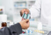 pharmacist handing blister pack of capsules to customer
