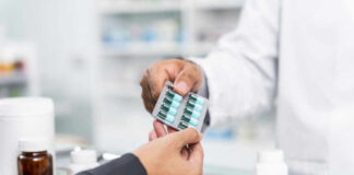 pharmacist handing blister pack of capsules to customer