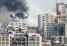 Hamas Chief Taken Out—Deif’s Shadowy End A view of destroyed buildings with smoke rising in the background