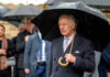 Man holding umbrella in rainy weather with crowd