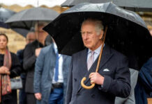 Man holding umbrella in rainy weather with crowd