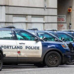 Mysterious Crash Sparks Explosive Fears Row of Portland police cars parked on street.