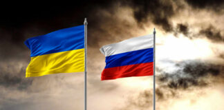 Ukrainian and Russian flags on poles against a dramatic cloudy sky