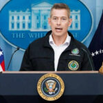 Duffy SLAMS Biden Over Airline Merger Disaster Man speaking at podium with presidential seal and flags