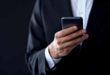 Media Frenzy: Missing Texts Fuel Speculation Businessperson in suit holding a smartphone
