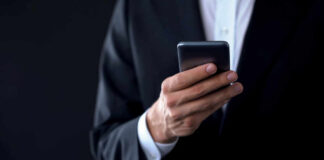 Businessperson in suit holding a smartphone