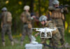 A military drone being prepared for use with soldiers in the background