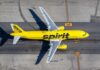 A yellow Spirit Airlines airplane on an airport runway