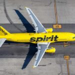 A yellow Spirit Airlines airplane on an airport runway