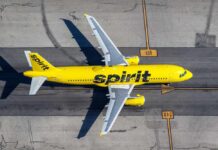 A yellow Spirit Airlines airplane on an airport runway