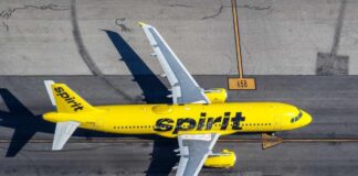 A yellow Spirit Airlines airplane on an airport runway