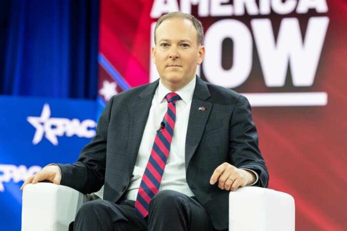 A man in a suit sitting on a white chair at a political conference