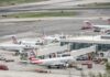 Multiple American Eagle aircraft parked at an airport terminal with ground crew present