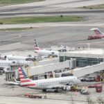 Multiple American Eagle aircraft parked at an airport terminal with ground crew present