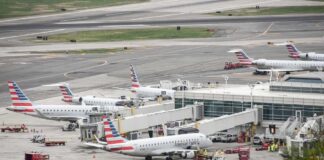 Multiple American Eagle aircraft parked at an airport terminal with ground crew present