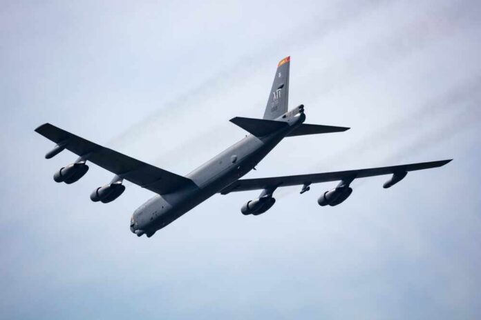 A B-52 bomber flying in the sky with visible jet engines