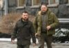 Two men in winter jackets walking outdoors in an urban area