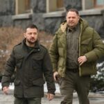 Two men in winter jackets walking outdoors in an urban area