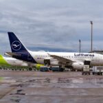 Middle East Chaos Sparks Airline Cancellations Two airplanes parked at an airport with ground service vehicles nearby