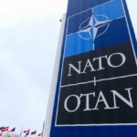 Strait of Hormuz: Will NATO Act or Fold? NATO sign with flags in the background