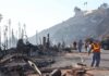 Workers cleaning up debris from a wildfire-affected area